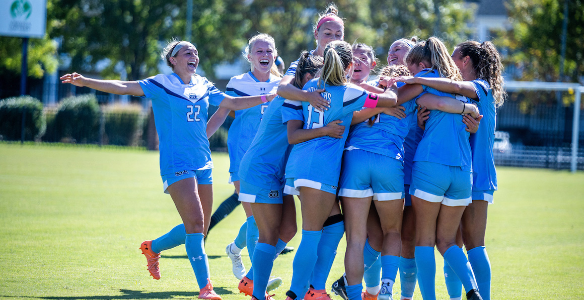 Old Dominion University's women's soccer team rejoicing in group hug